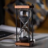 AKAKA MUNING front view of black wooden 60-minute hourglass showing full frame and glass — decorative timing.