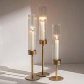 Glasseam front view of three gold hurricane holders shows elegant silhouette and coordinated heights