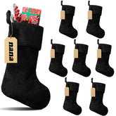 Glimin front view of eight black stockings showing matching plush finish and wood tags for cohesive decor