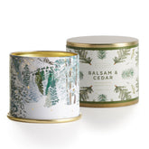 Illume balsam & cedar front-facing tin showing holiday illustration and fragrance appeal