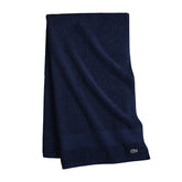 Lacoste folded navy towel front view showing plush feel and refined look