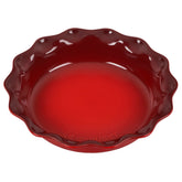 Le Creuset Heritage pie dish front view showing cerise glaze and scalloped rim for elegant serving