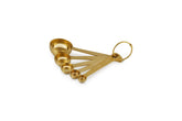 Le Creuset front view of measuring spoons set shows polished gold finish and tidy nesting