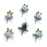 Ling's Moment front view showing six dusty blue boutonnieres, organized and ready