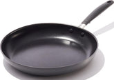 OXO 12-inch frying pan front view showing sleek black finish and rim, durable cooking
