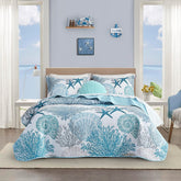 Tritard front view of coastal king quilt showing beach print and calming blue tones