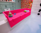 Tub Topper front view pink showing compact splash guard and neat storage benefit