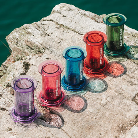 AeroPress clear blue packed in backpack showing durable brewer for outdoor use