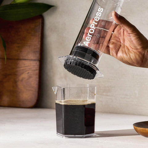 AeroPress Clear XL next to a mug demonstrating 20 oz capacity and serving scale