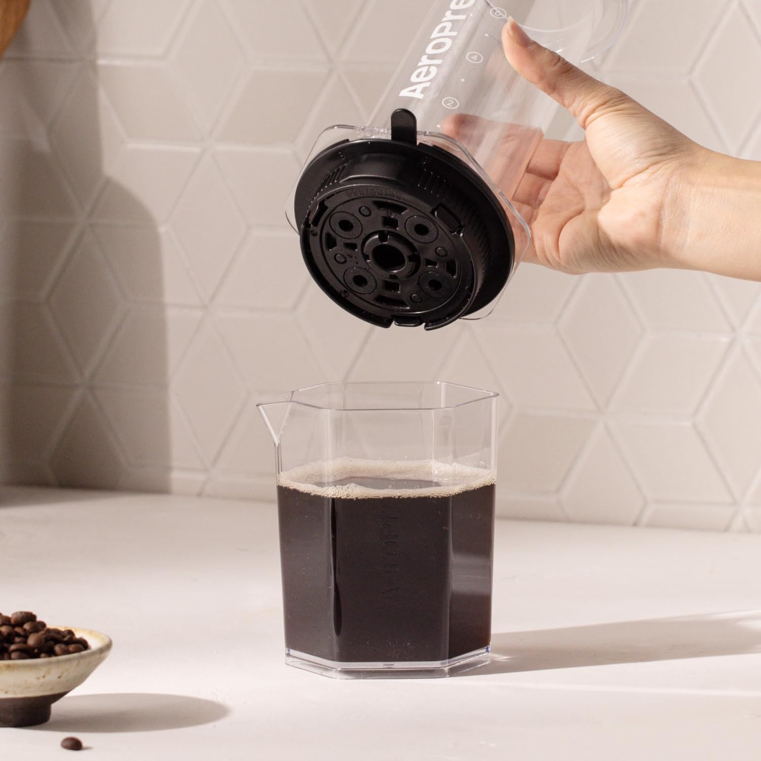 AeroPress XL cap in hand to show compact size and portable convenience