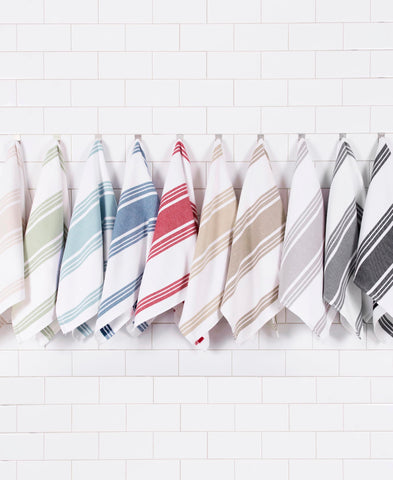 All-Clad towel styled on a kitchen counter with cookware to demonstrate coordinated aesthetic