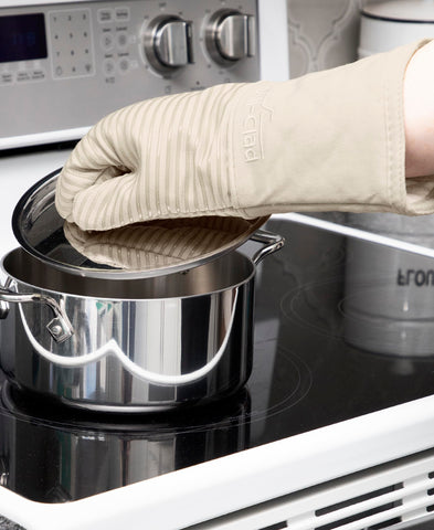 All-Clad mitt in use with a hot baking sheet showing secure handling benefit