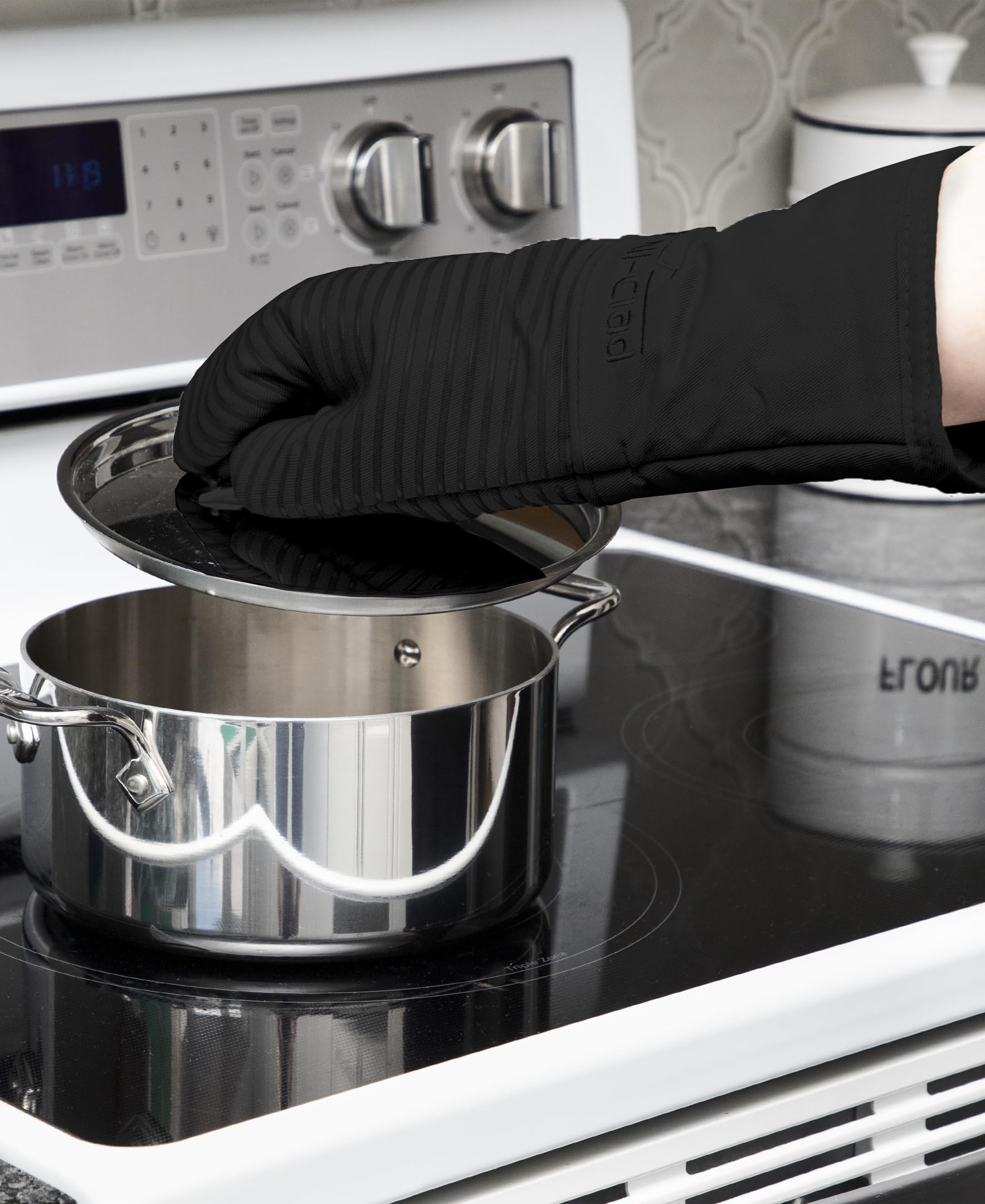 All-Clad mitt gripping a hot pan to show confident handling and heat defense