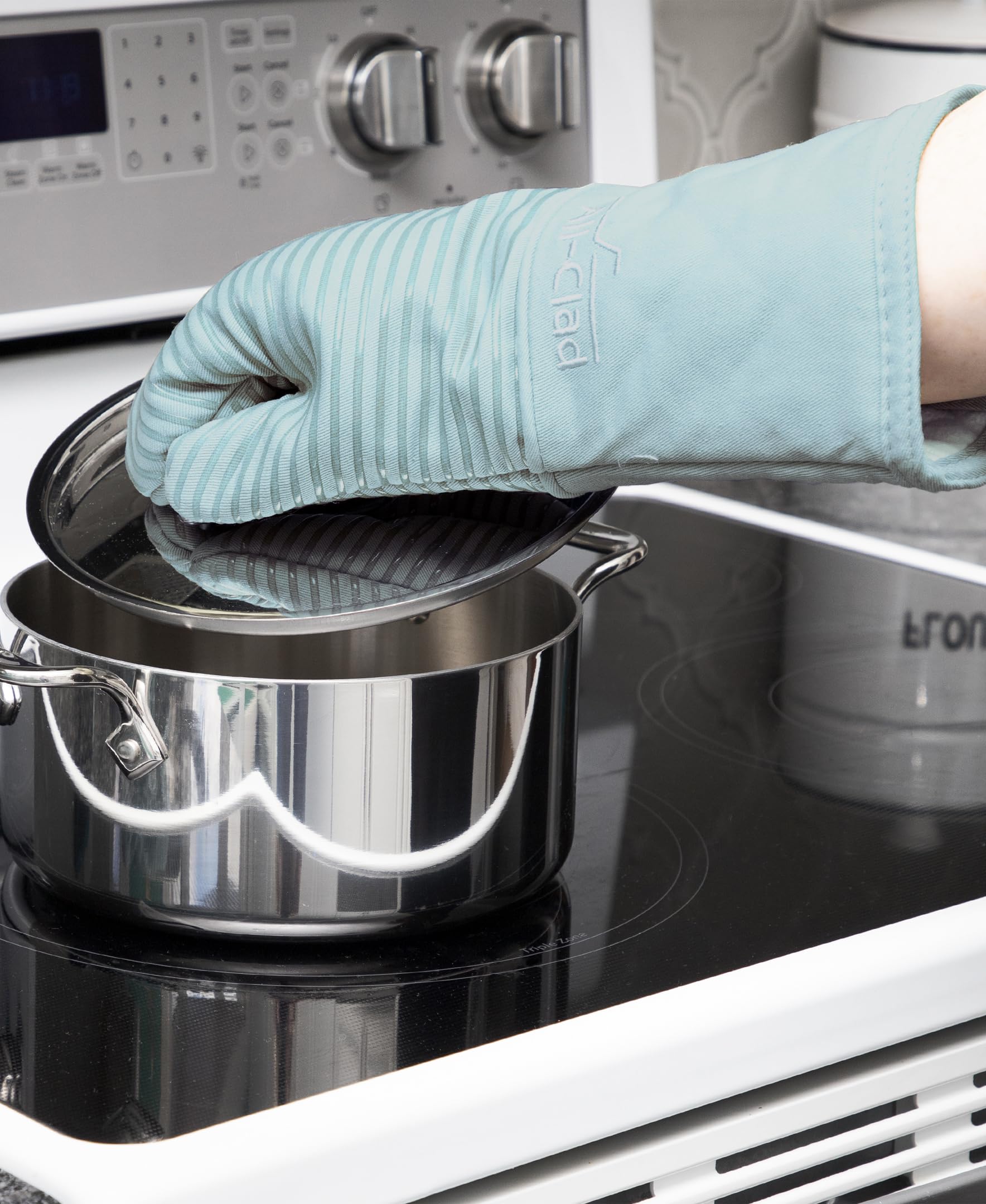 All-Clad mitt gripping a hot pot handle with stable control