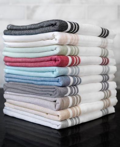 All-Clad towel next to a dinner plate to show the generous 17x30 inch size and coverage