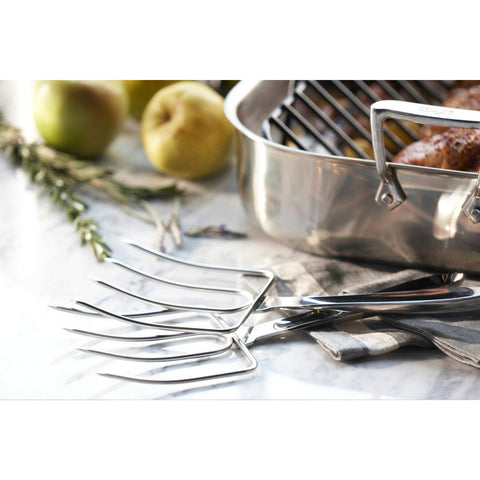 All-Clad turkey forks lifting roasted turkey with stable grip for safe transfer and carving