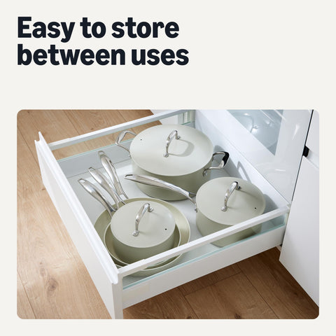 Amazon Basics pans held in hand to show scale and lightweight recycled-aluminum construction for easy handling