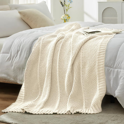Amélie Home throw styled on bed creating soft, neutral bedroom ambiance