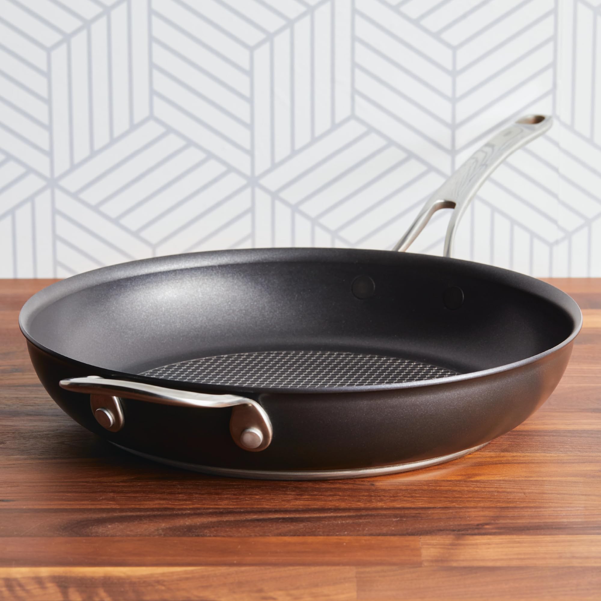 Anolon X base close-up highlighting thick stainless base for even heat distribution and stability