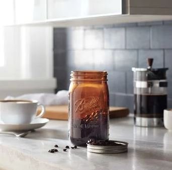 Ball jar held in hand showing 32 oz scale and usability benefit
