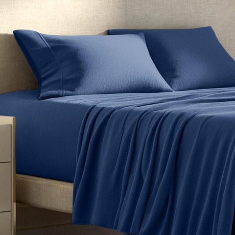 Bare Home styled bedroom with sheets on made bed, illustrating inviting cozy atmosphere