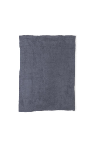 Barefoot Dreams folded throw on bed demonstrating compact storage and elegant layering benefit