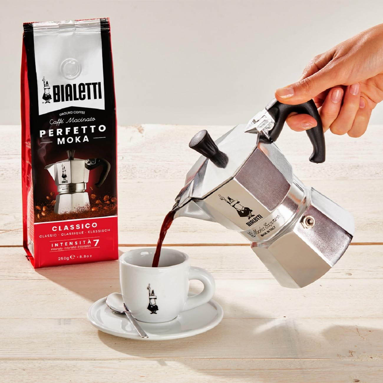 Bialetti pouring action into espresso cup demonstrating steady pour and control