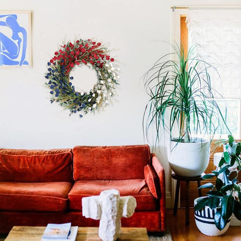 Bibelot wreath on a covered porch creating seasonal, low-maintenance decor charm