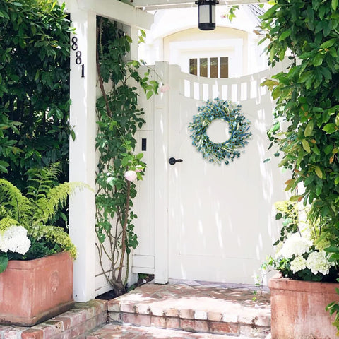Bibelot wreath displayed on a covered front door adding farmhouse charm