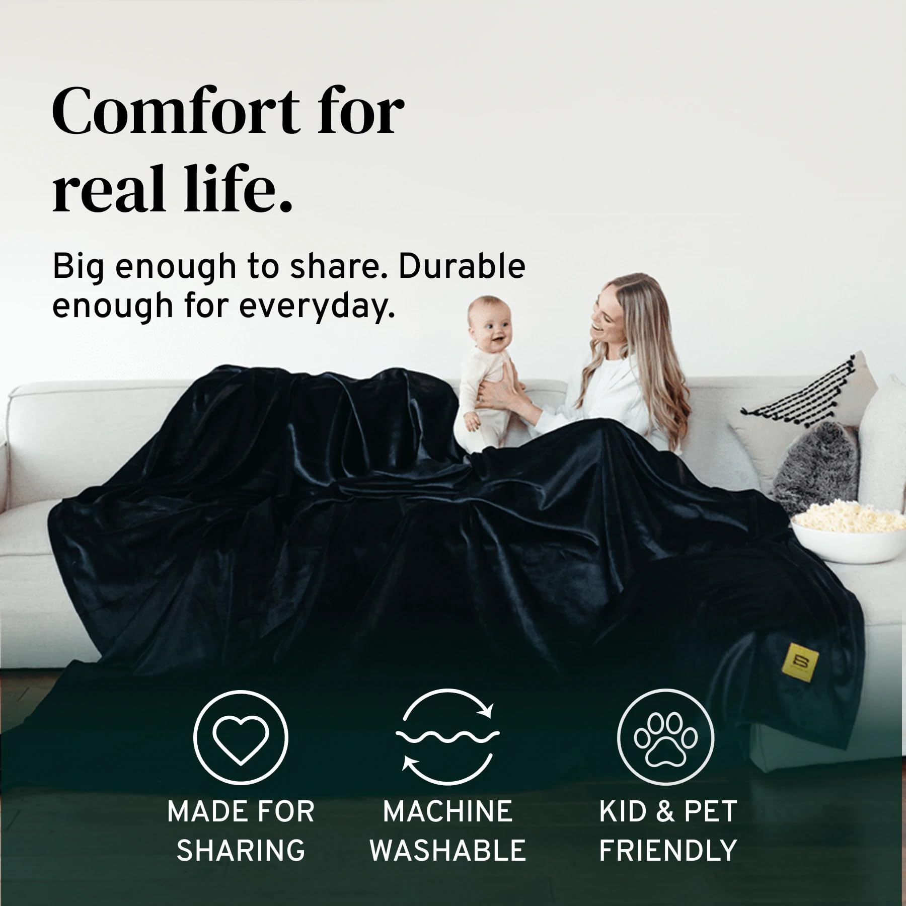 Big Blanket Co on sofa lifestyle displays roomy coverage and stylish black color
