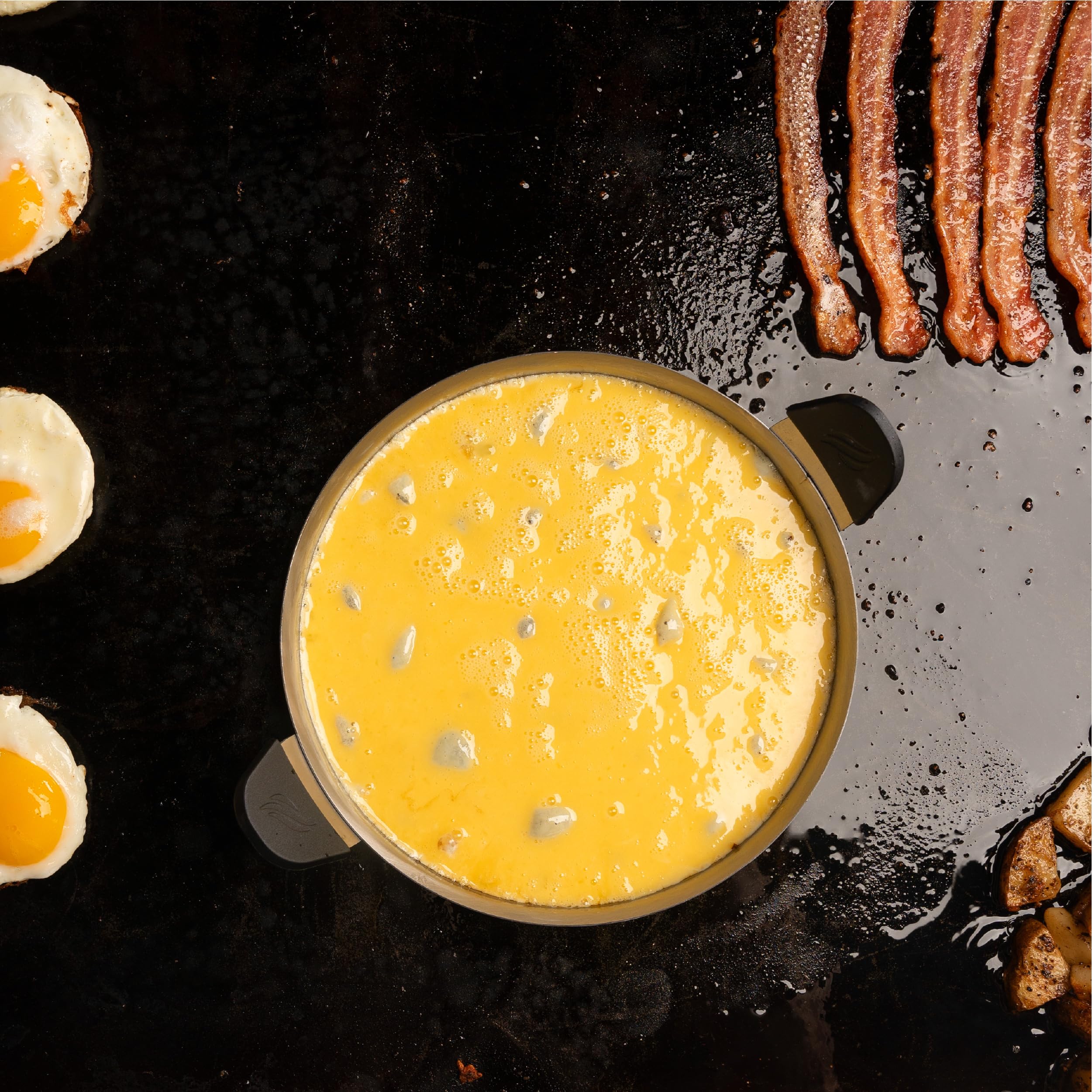 Blackstone tools next to griddle cooking pancakes and eggs for easy breakfasts