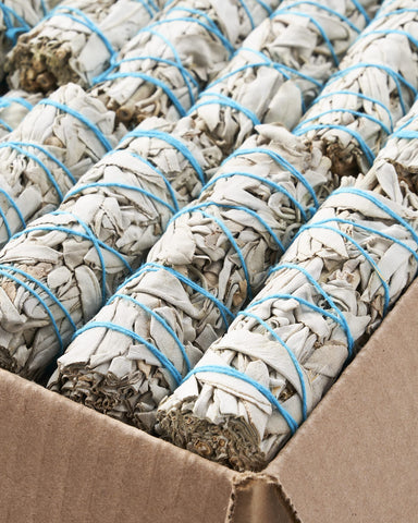 Blue River Sage smudge stick burning in a heatproof bowl demonstrating safe use