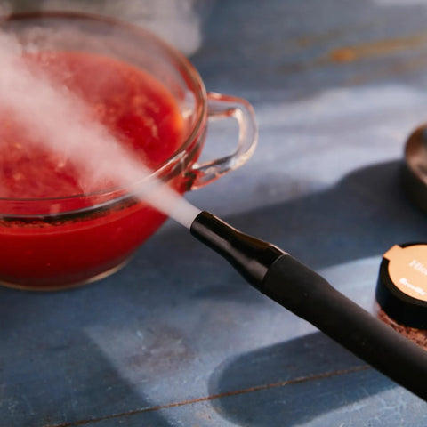 Breville Smoking Gun infusing smoke into a cocktail glass for aroma