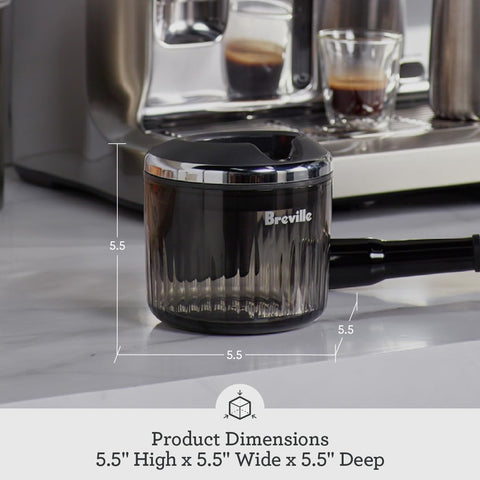 Breville puck sucker next to hand for size scale and countertop fit