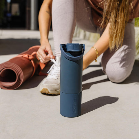 BrüMate Rise sitting in a car cup holder showing cup-holder-friendly fit for commutes and travel