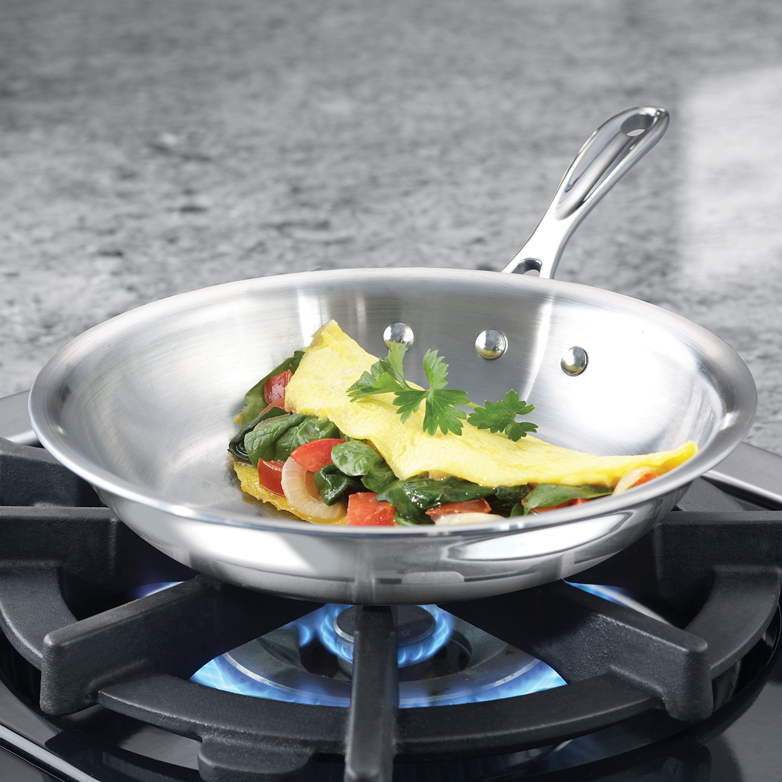 Calphalon omelette pan close-up of stainless interior and aluminum core layers, even-heating benefit