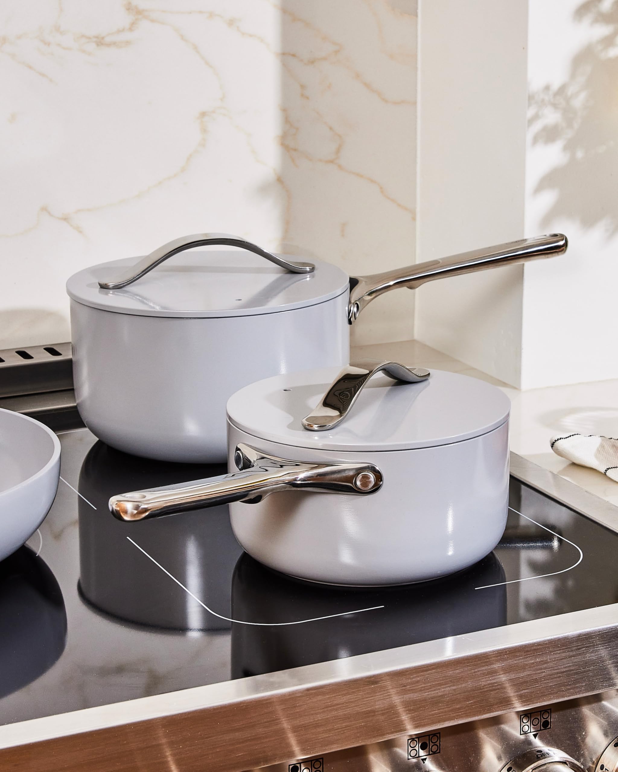Caraway saucepan next to apple for size comparison showing compact capacity benefit