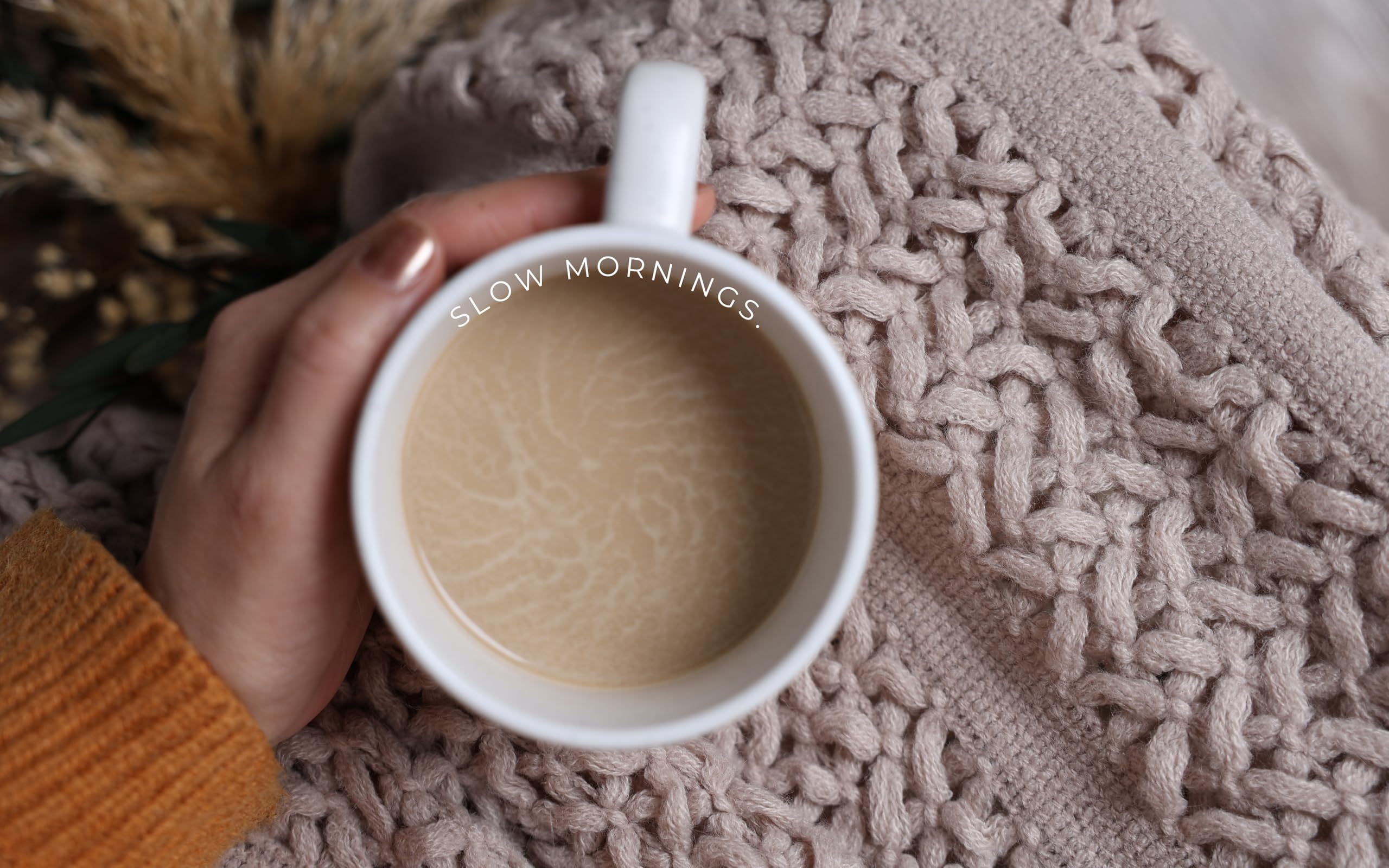 CASTATEO lifestyle scene of throw, candle, and mug encouraging rest
