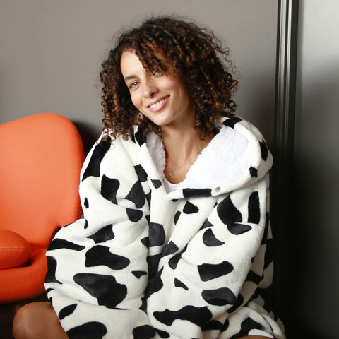 Person wearing Catalonia hoodie blanket while lounging, demonstrating comfort and mobility