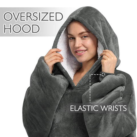 Catalonia lifestyle shot of model wearing hoodie blanket on sofa demonstrating comfy lounging