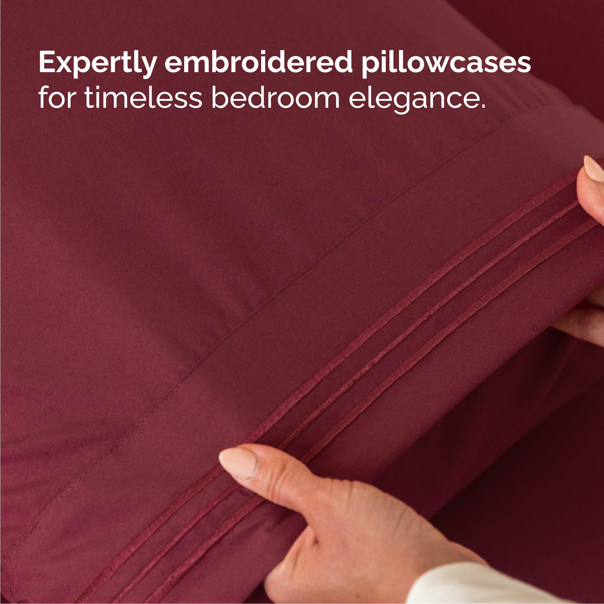 CGK Unlimited made bed in bedroom lifestyle scene showing burgundy sheets adding warm decor.