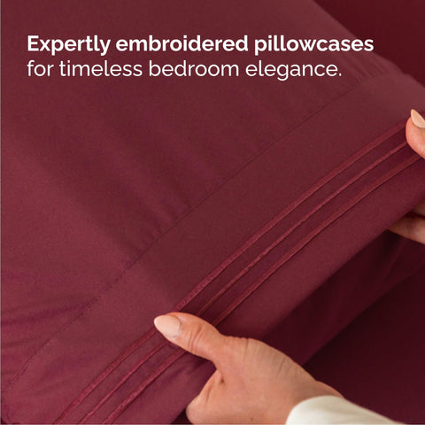 CGK Unlimited made bed in bedroom lifestyle scene showing burgundy sheets adding warm decor.