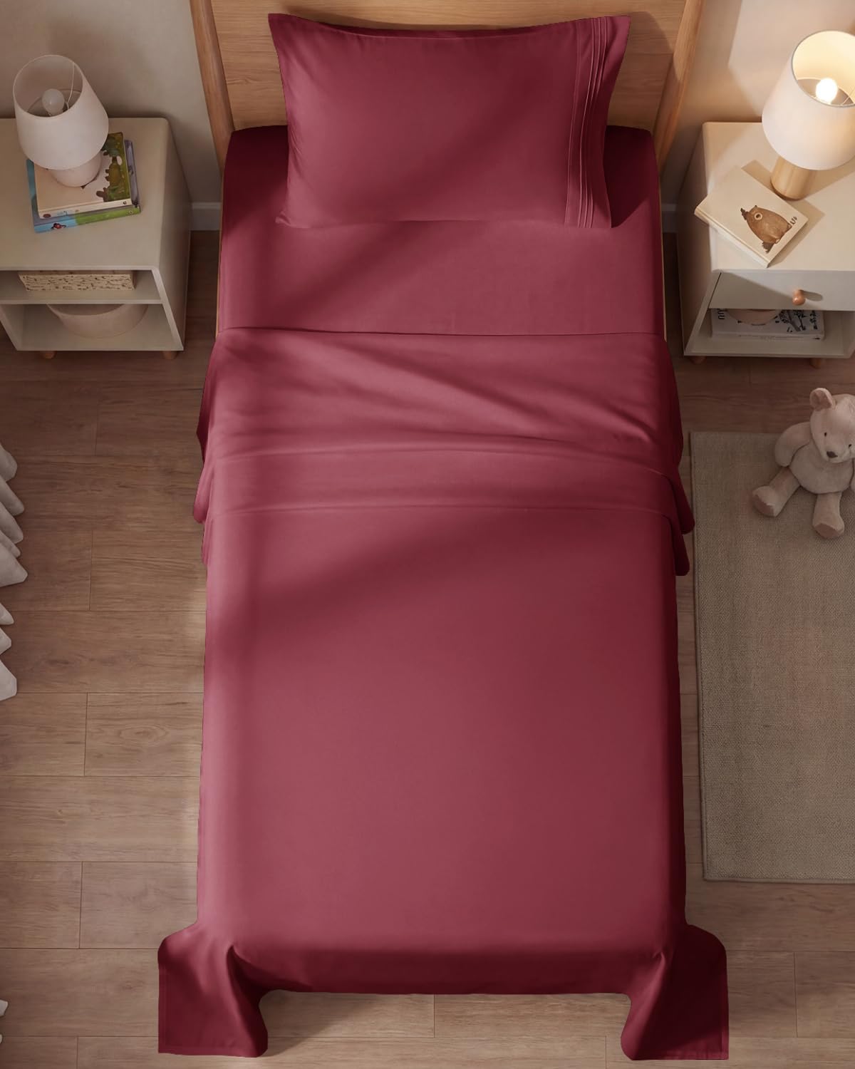 CGK Unlimited styled twin bed with burgundy sheets showing polished bedroom look
