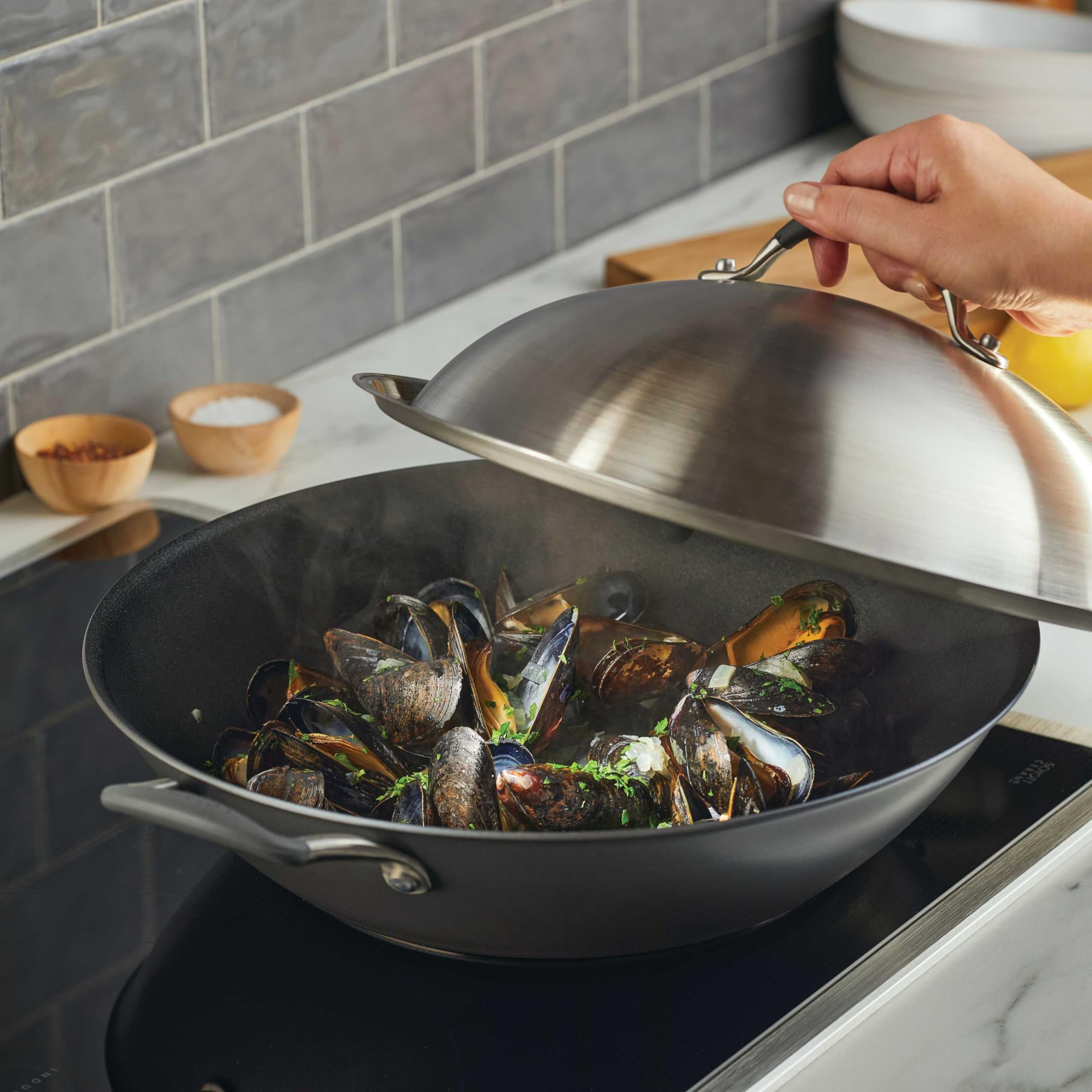 Circulon close-up of stainless steel lid and rubberized grip, secure steam retention benefit.