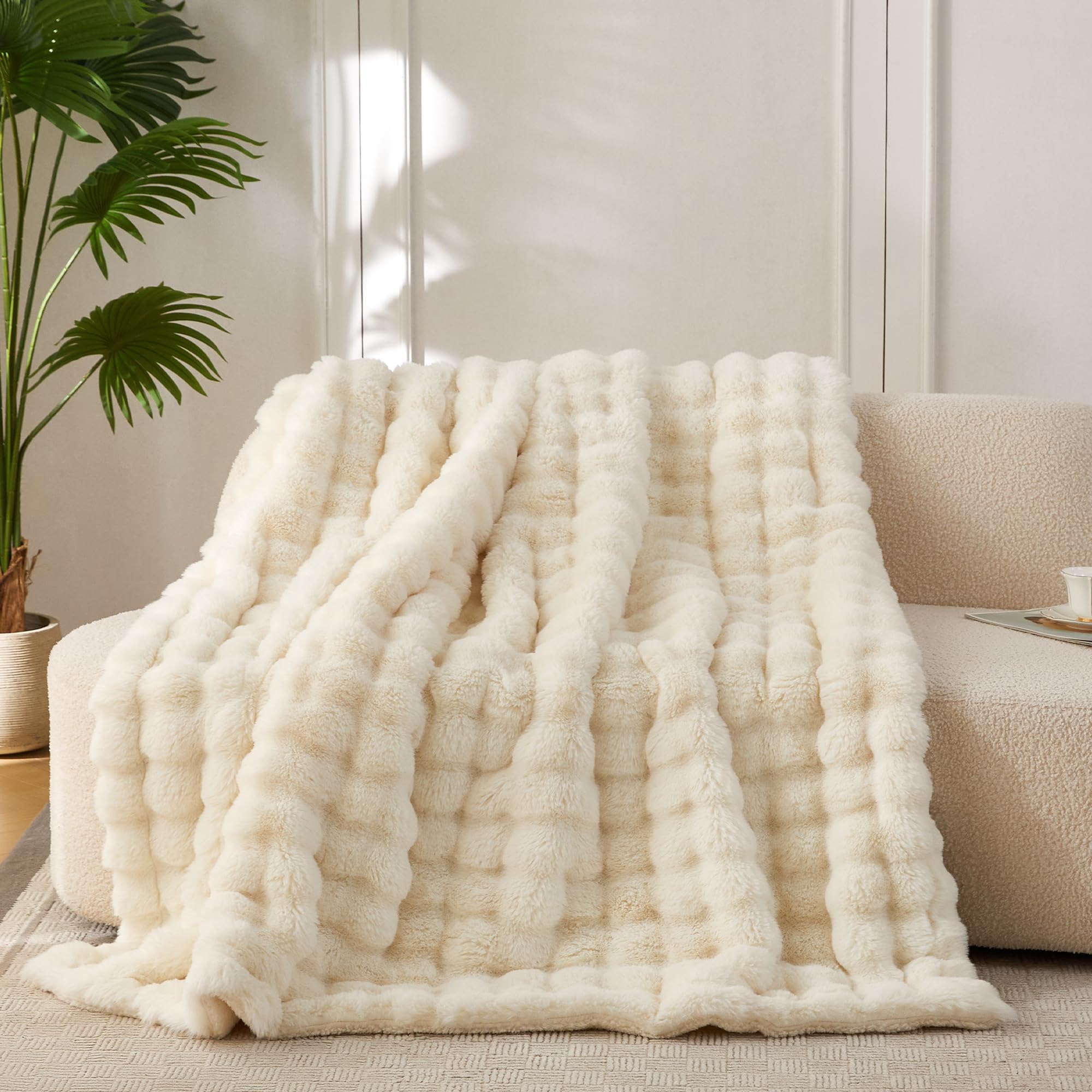 COOVA throw front view on couch showing smooth ivory finish and cozy look