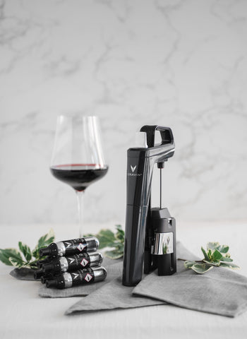 CORAVIN capsules on kitchen counter next to wine glass, preserving opened bottles at home