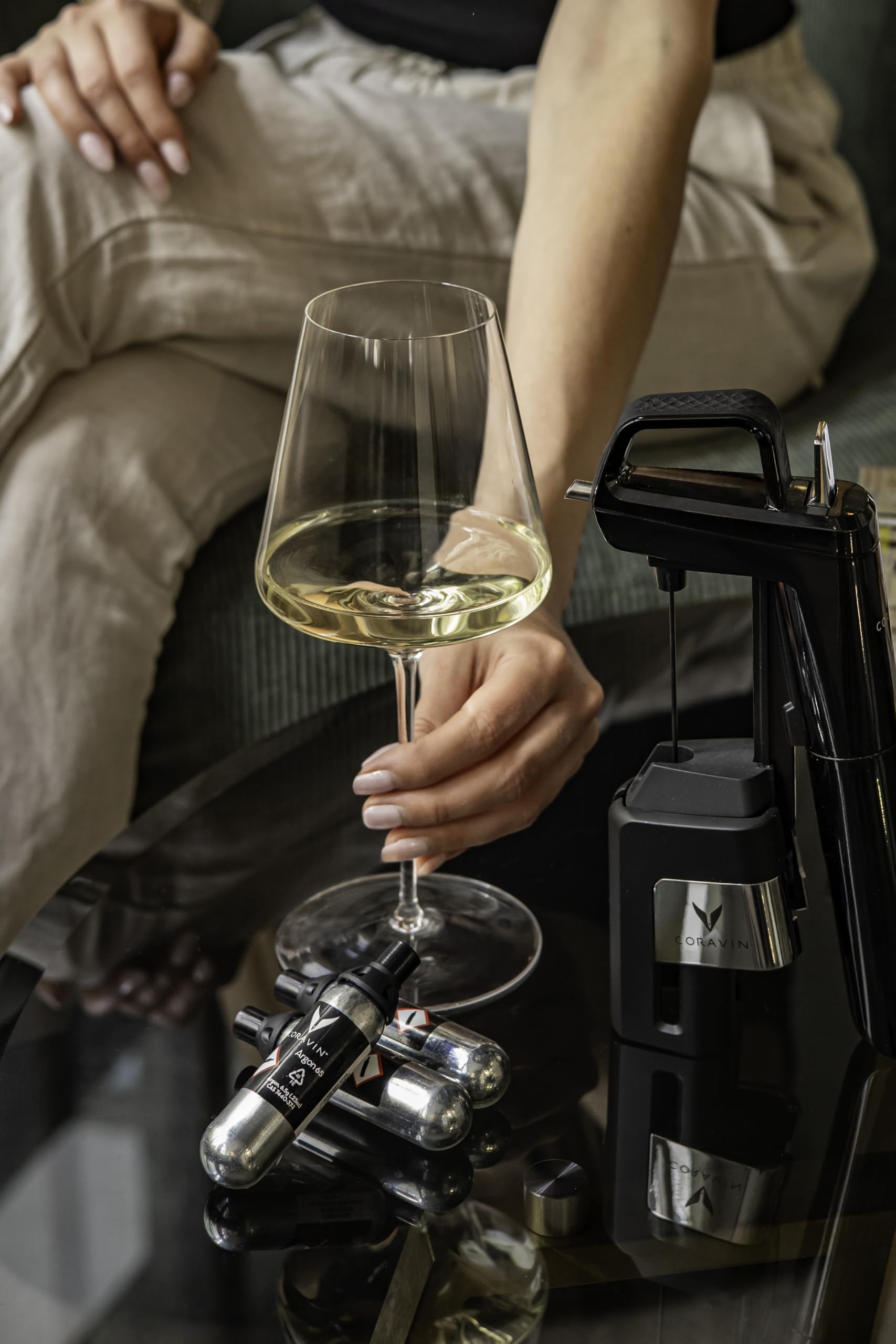 CORAVIN capsule next to a wine bottle for size comparison, clear visual of scale and portability