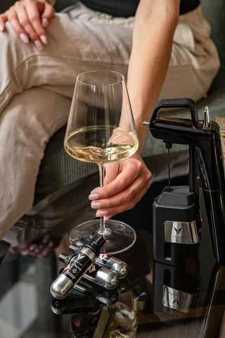 CORAVIN capsule next to a wine bottle for size comparison, clear visual of scale and portability