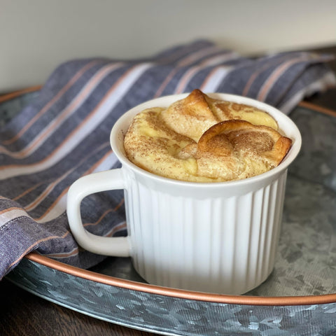CorningWare mug held by hand for size comparison, clarifies 20oz capacity