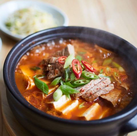Crazy Korean Cooking dolsot on stovetop with steam rising, demonstrates even heat retention